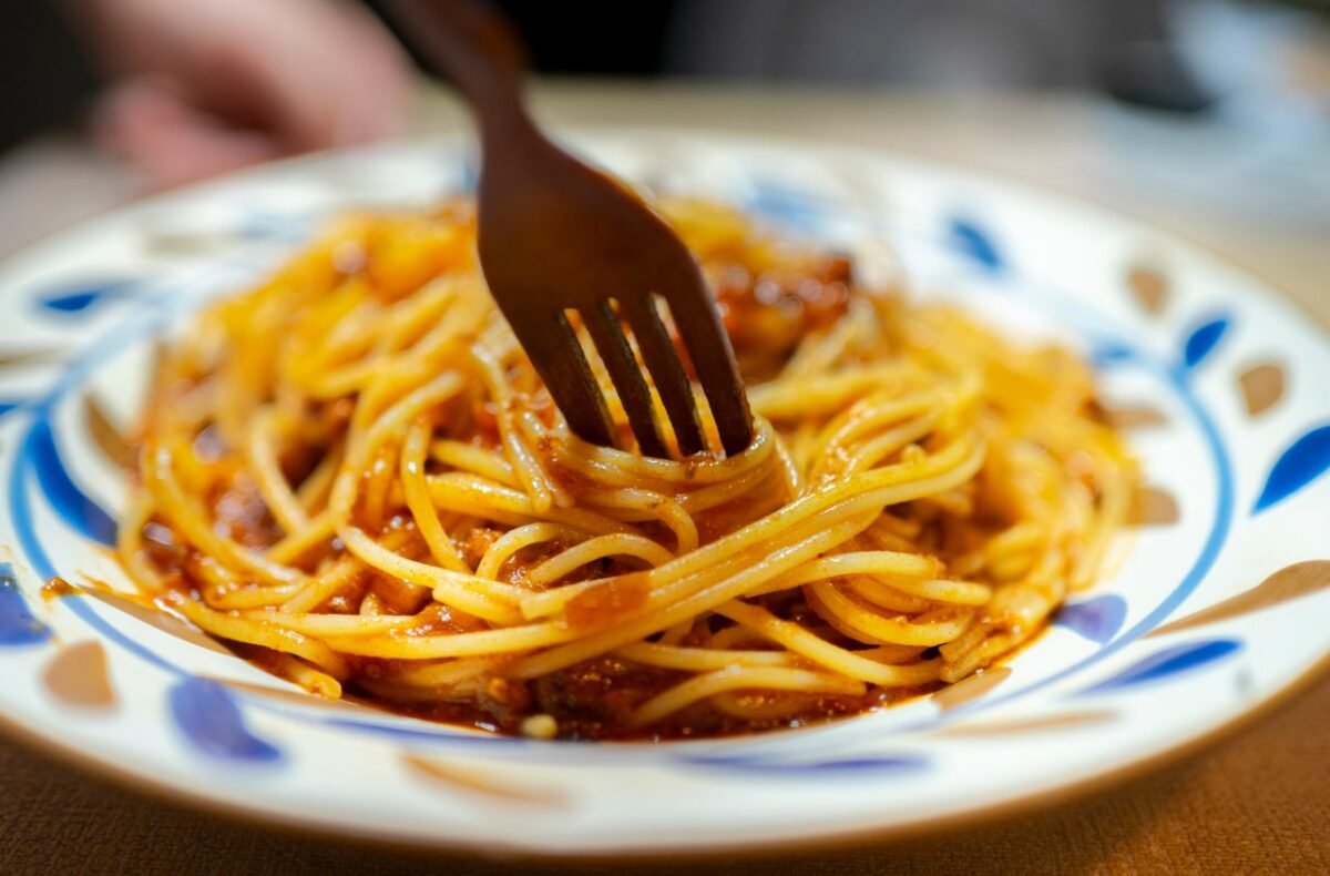 Delicious spaghetti with rich tomato sauce served on an artistic plate, fork ready to dig in.
