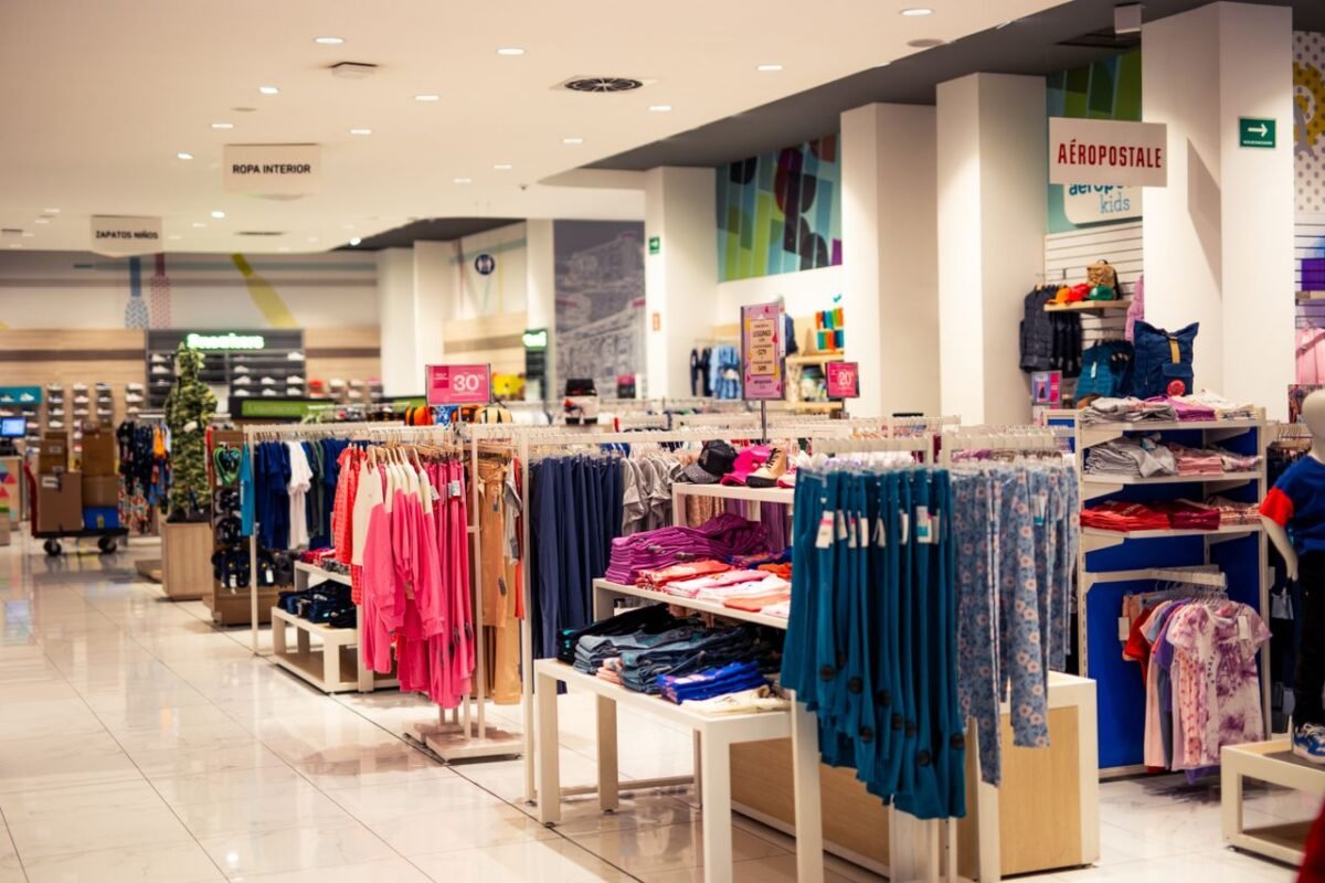 Interior of a modern department store with clothing displays and signage, offering a trendy shopping experience.